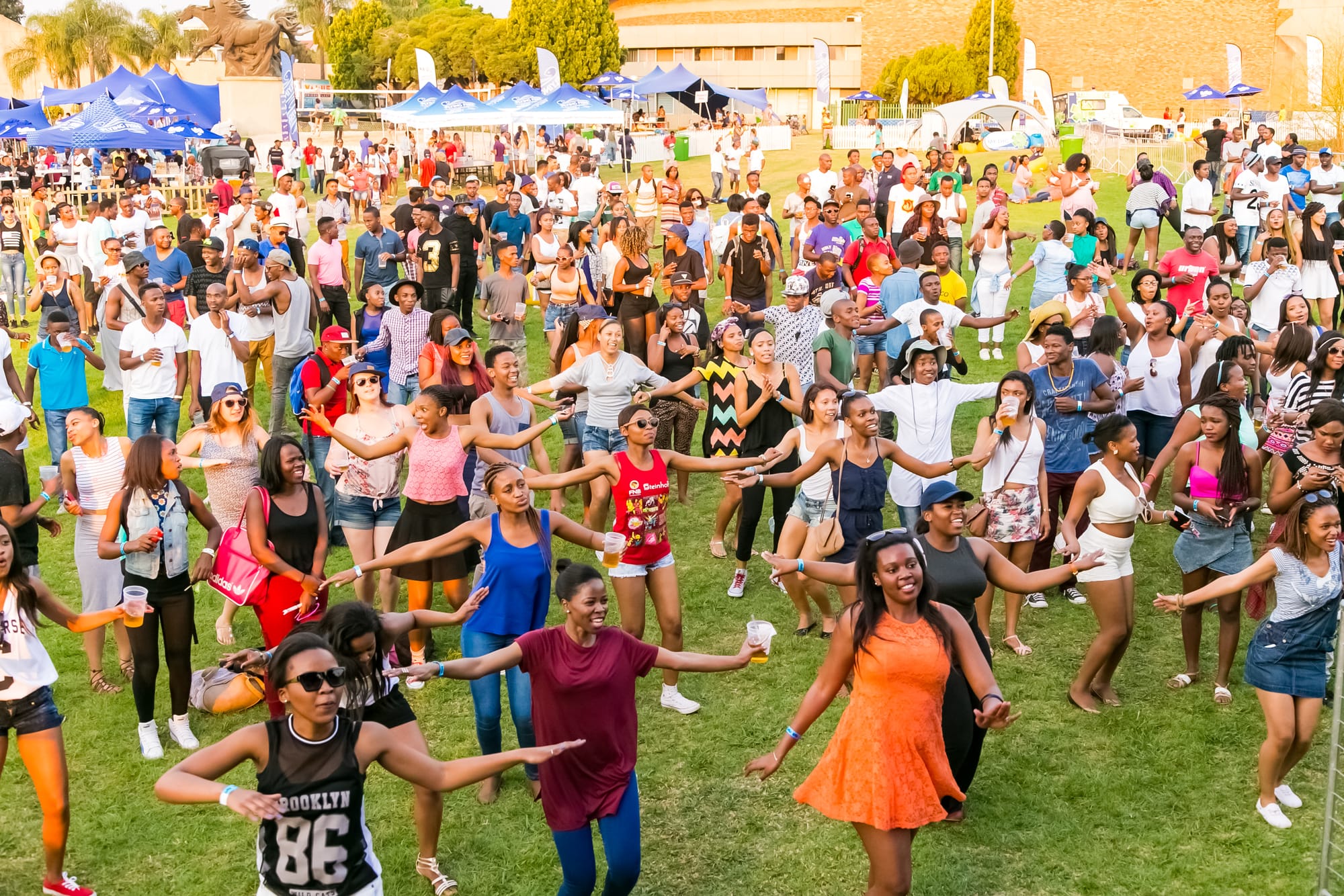 Group of diverse people dancing and having fun at an outdoor concert in Johannesburg, South Africa
